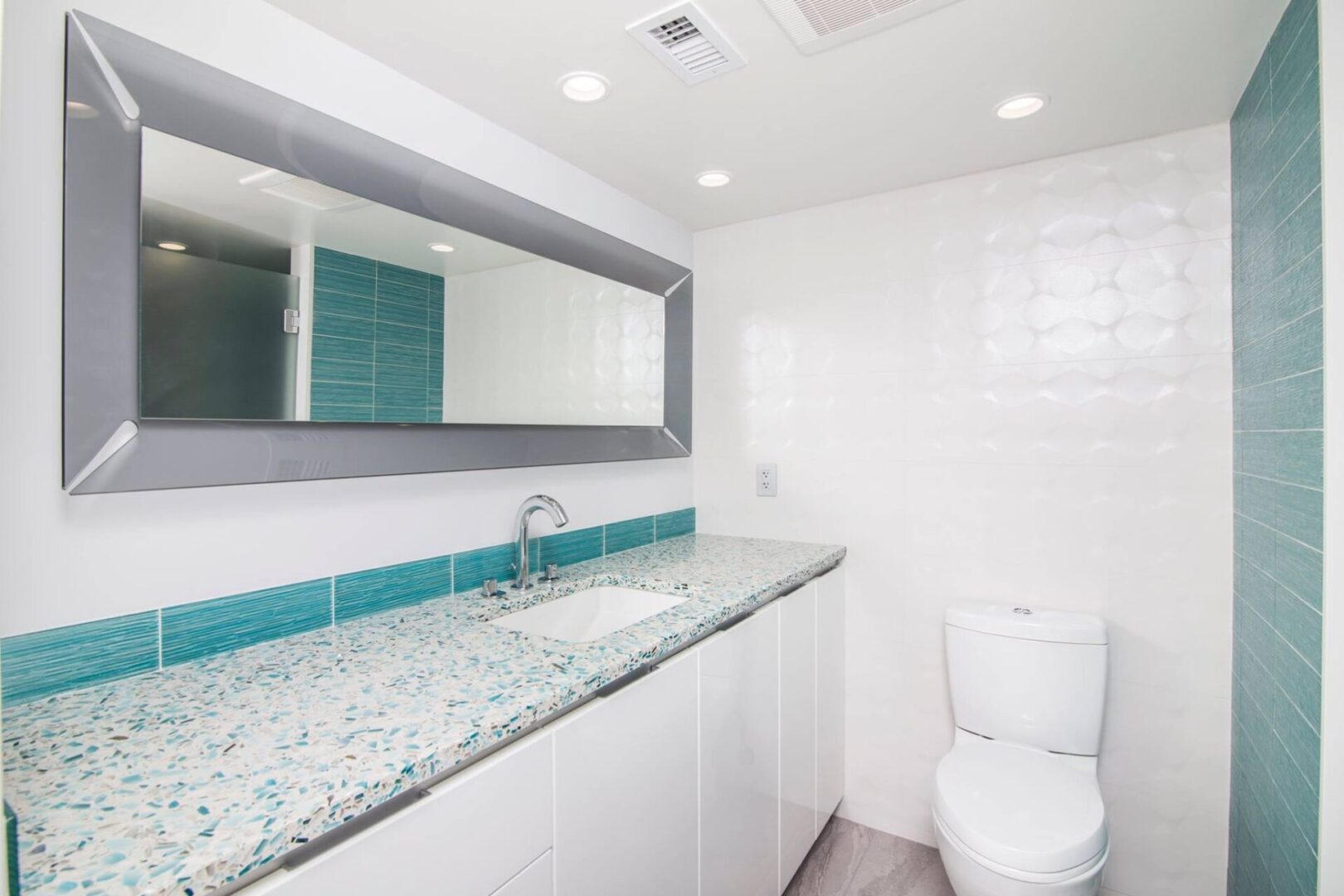 A bathroom with a sink, mirror and toilet.