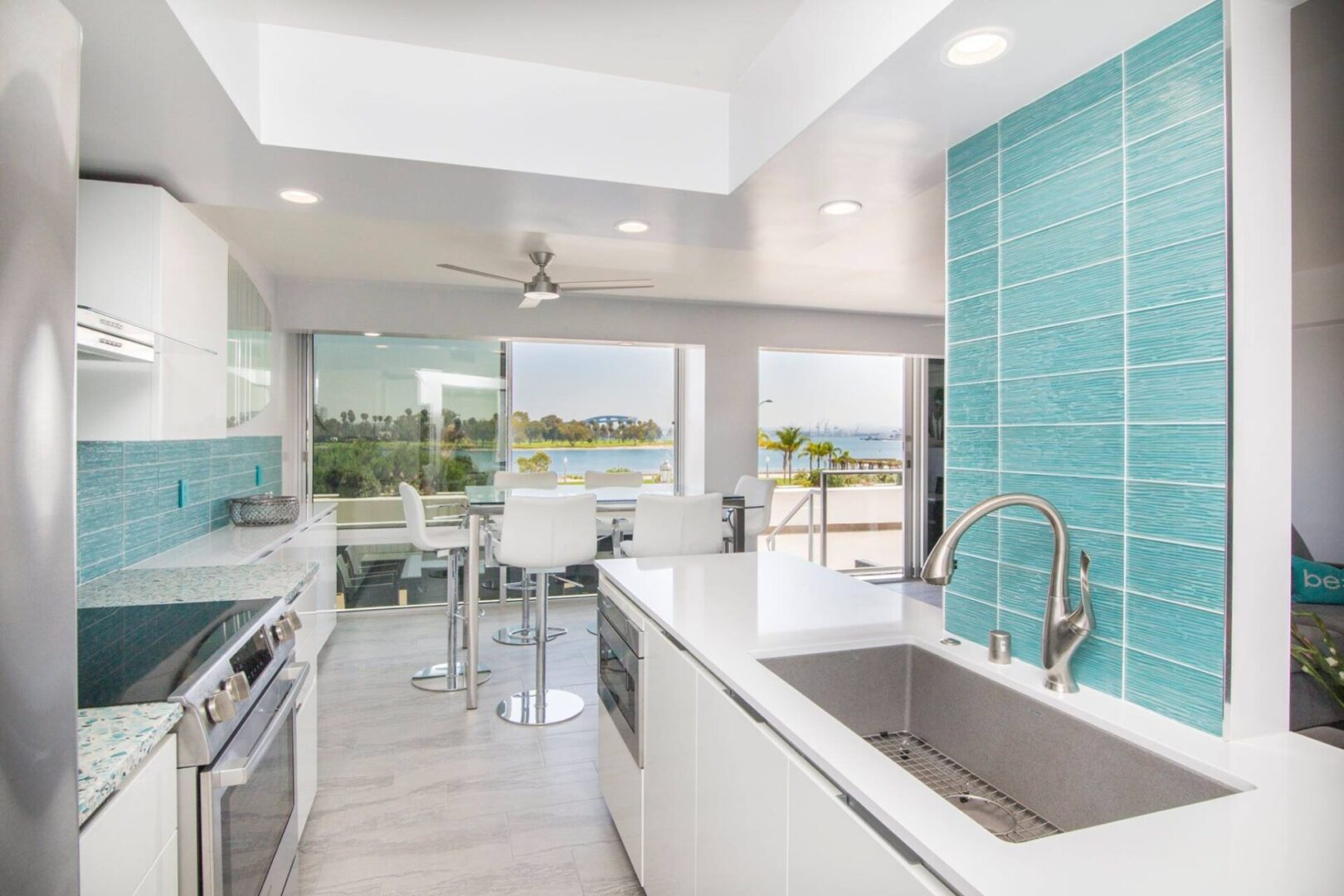 A kitchen with a sink, oven and microwave.