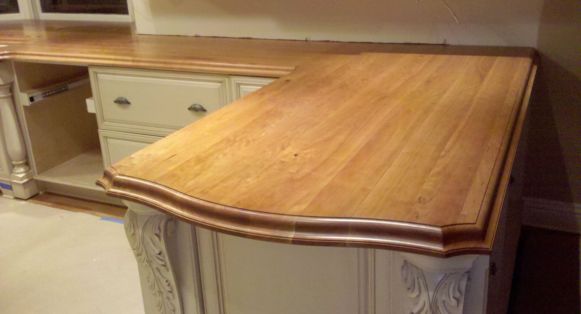 A wooden counter top in the middle of a kitchen.