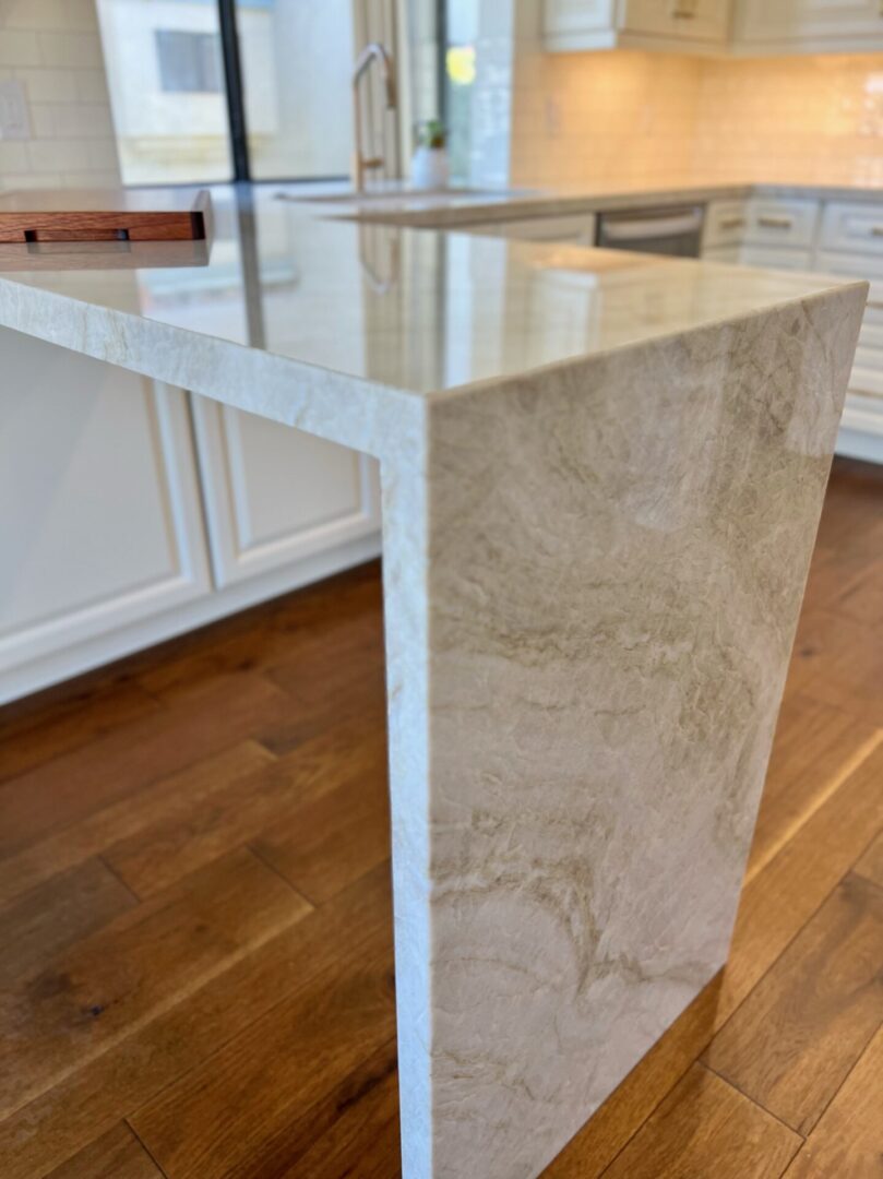 A kitchen with marble counter tops and wooden floors.