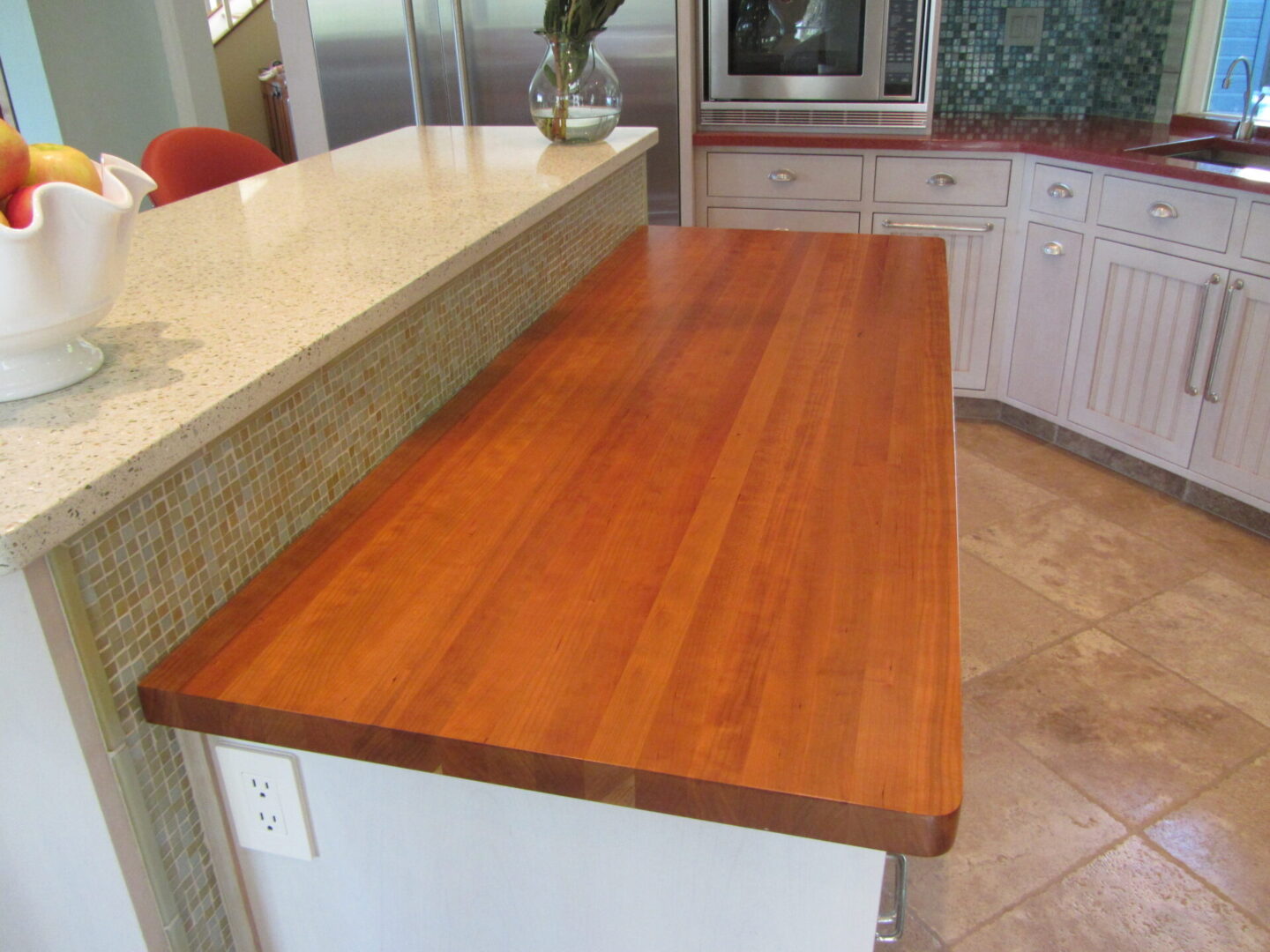 A wooden counter top in the middle of a kitchen.