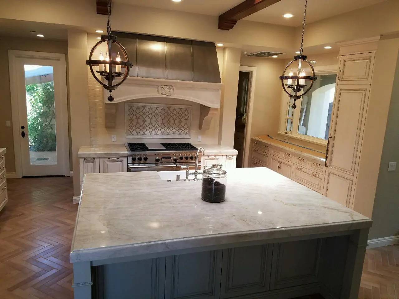 A kitchen with a large island and white cabinets.