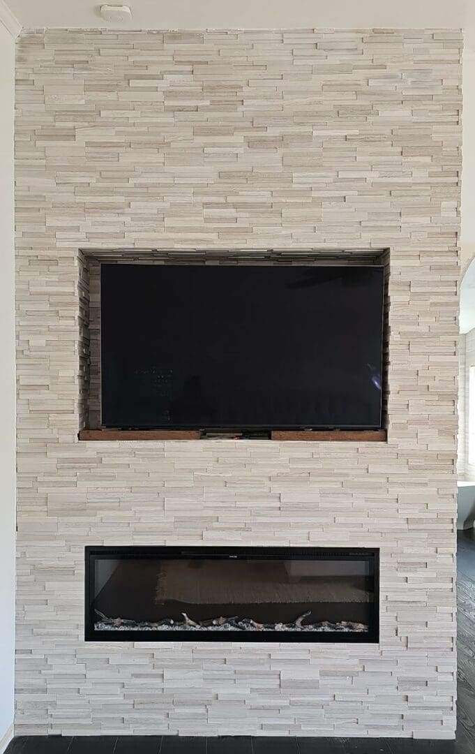 A fireplace with a flat screen tv mounted above it.