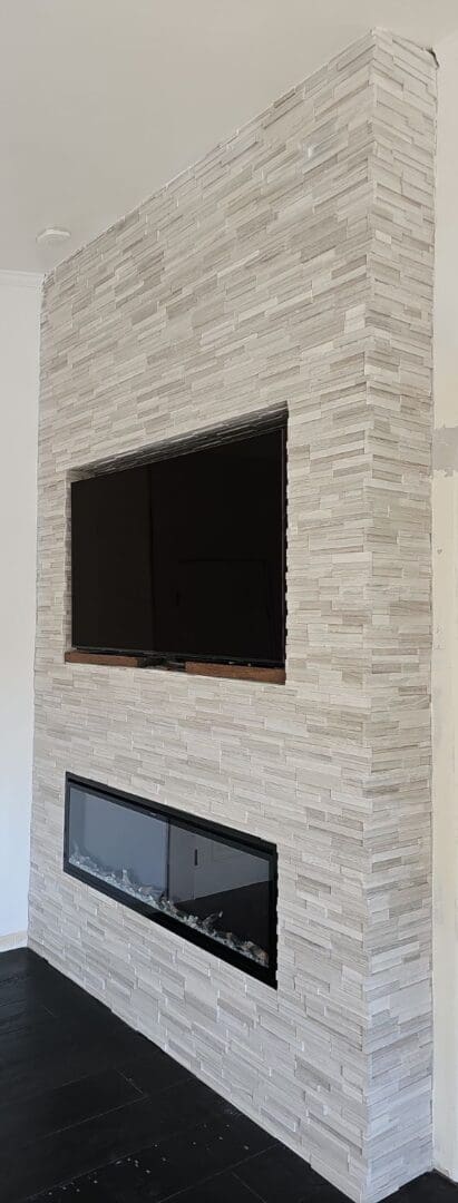 A fireplace with a flat screen tv mounted above it.