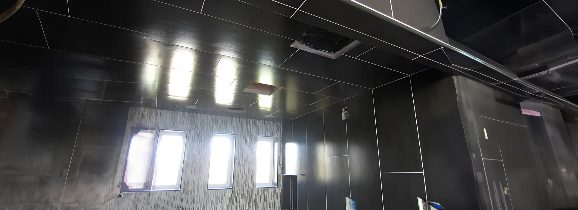 A bathroom with black tile and white walls.