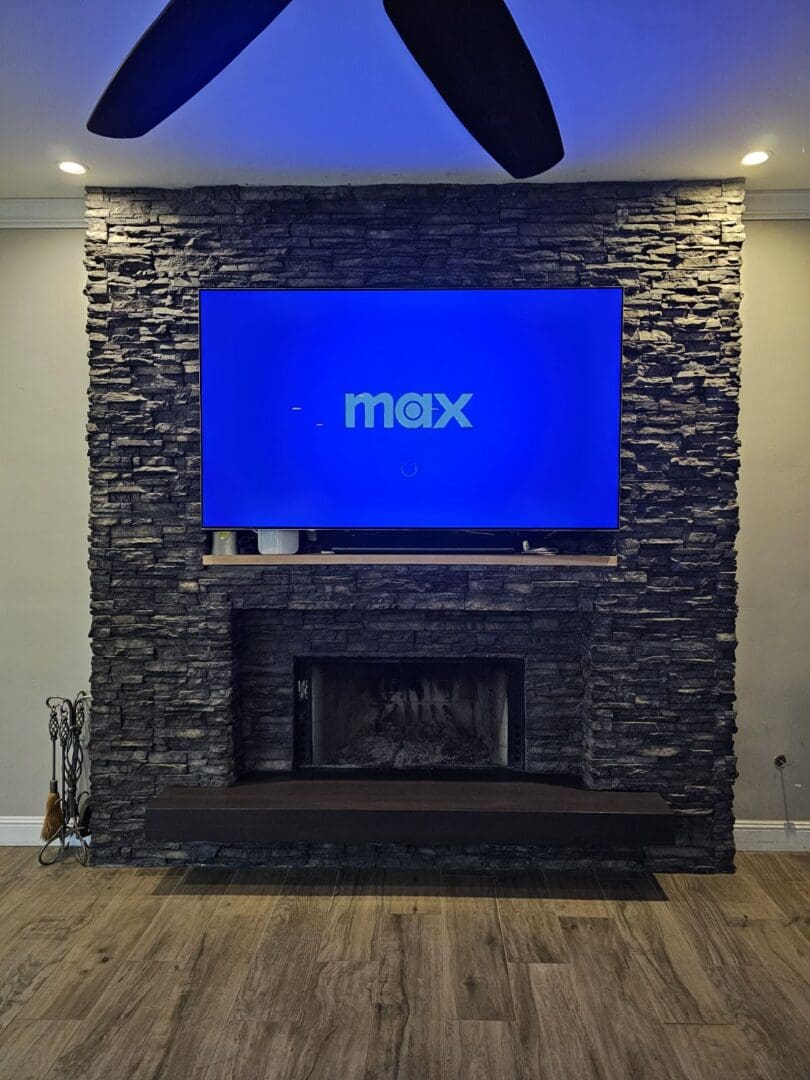 A fireplace with a flat screen tv mounted above it.