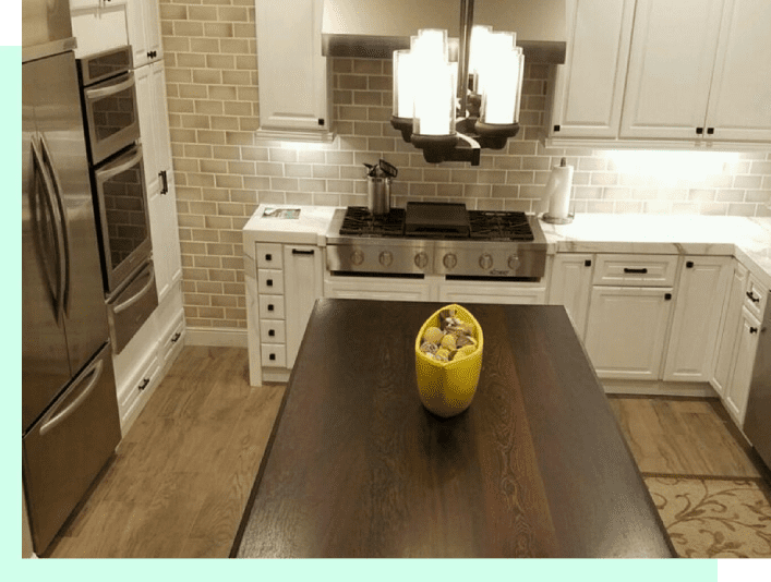 A yellow vase sitting on top of a wooden table.