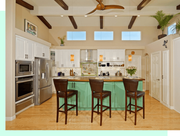 A kitchen with wooden floors and green cabinets.