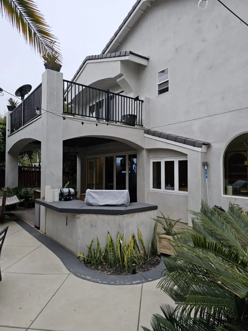 A patio with an outdoor kitchen and balcony.